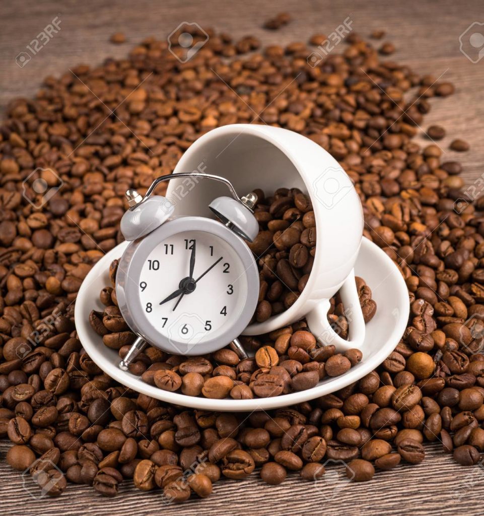 55312859 taza de granos de cafe reloj y cafe en una mesa 1
