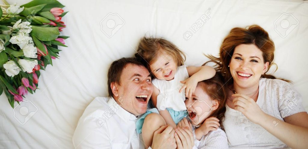 68535976 gran familia unida de cuatro personas alegremente pasa tiempo en camas dos ninas se encuentran 1